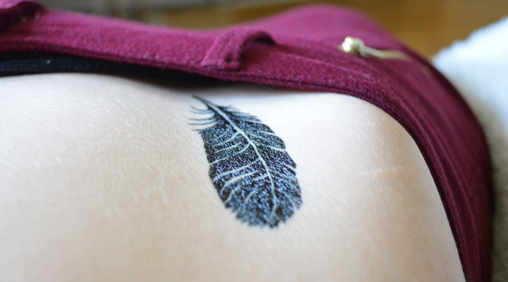 Tatouage de plume sur la hanche